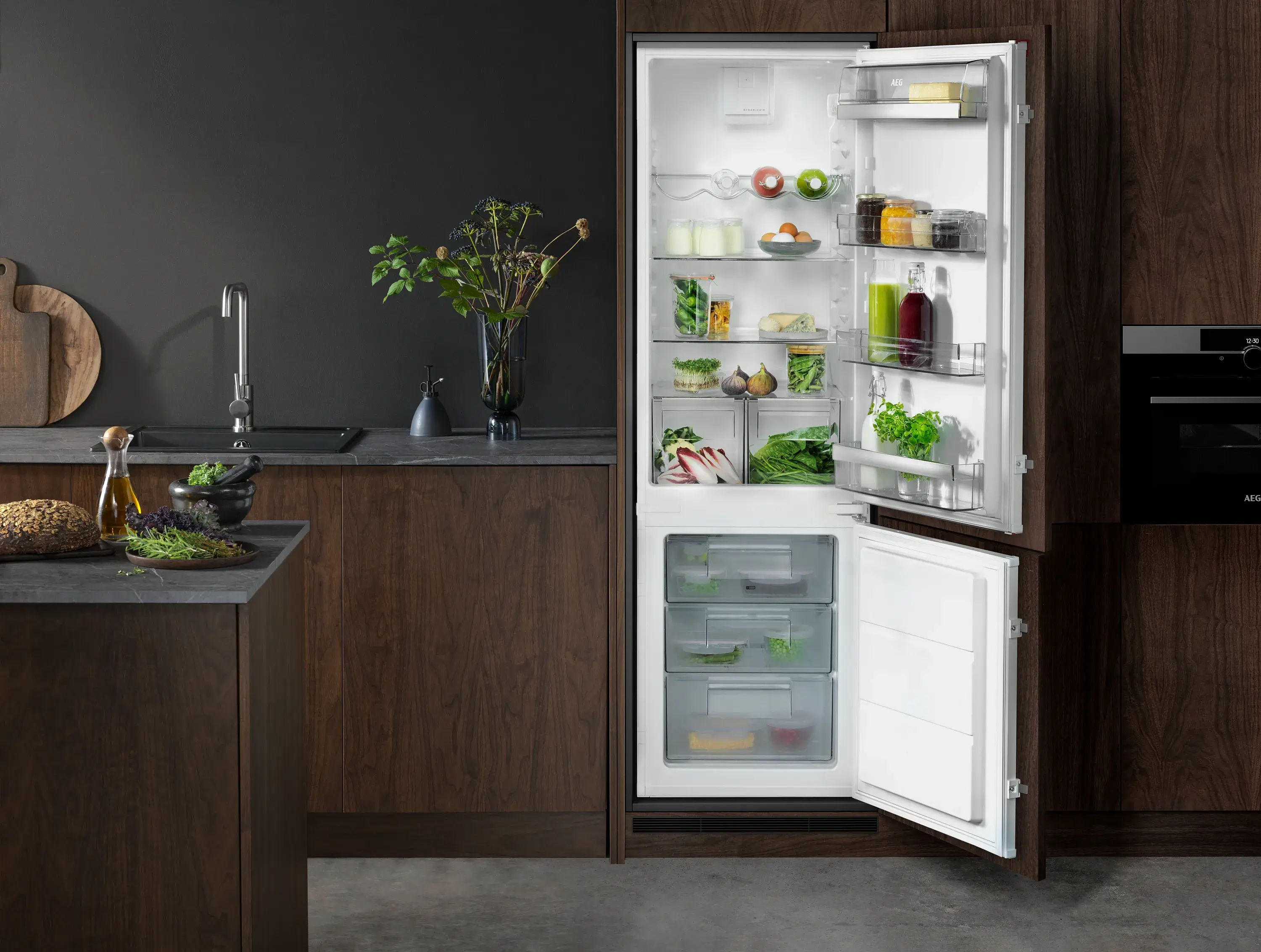 Kühlschrank in moderner Küche, Türen geöffnet, mit Lebensmitteln gefüllt.